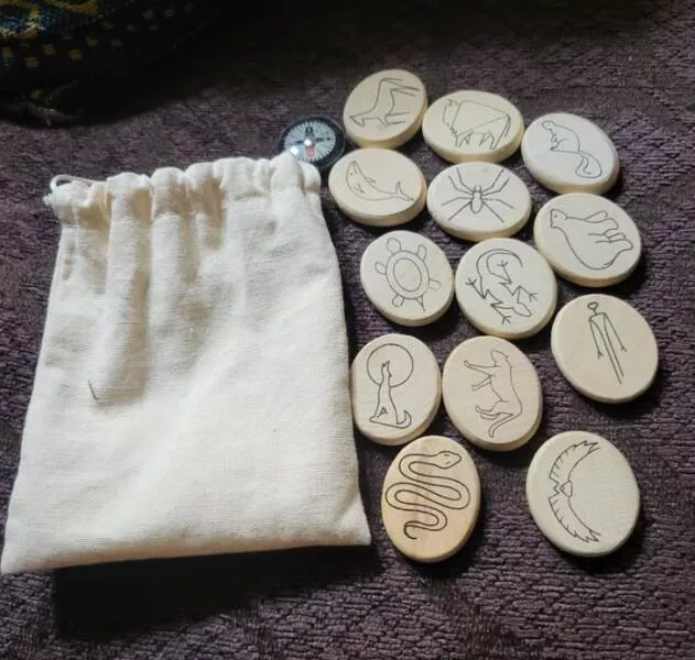 Revealing mysteries unveiling the secrets of enigmatic objects - #20 I came across this linen bag full of small wooden ovals printed with images of different animals and a compass.