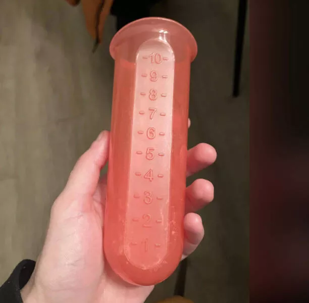 Reveler les mysteres decouvrir les secrets des objets enigmatiques - #26 I found this rigid pink tube at my Airbnb. It displays 3 holes on the bottom. It has some kind of a whitish residue. It's mostly cylindrical, but has a flat side with numbers to measure something.