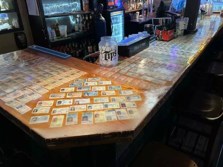 Intriguing discoveries subtly surprising finds that captivate - #24 This bar creatively adorned its bar top with confiscated fake IDs of college students