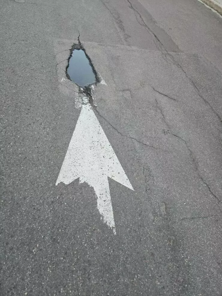 Photos curieusement fascinantes qui retiennent lattention - #36 L'ancienne flèche sur la route est maintenant un trou en forme de flèche