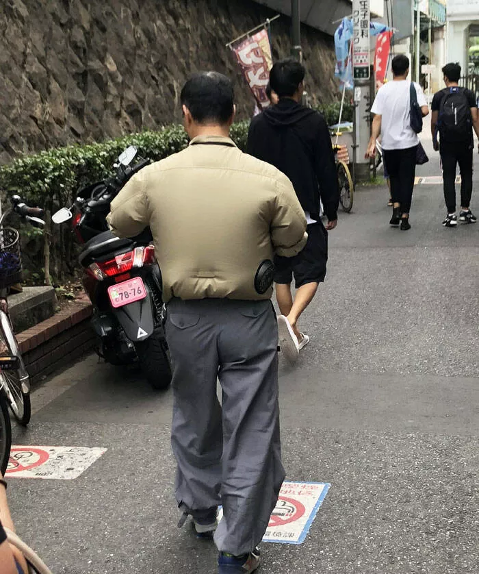 Capturing this summers extreme temperatures - #10 This guy in his cooling fan jacket is braving the 36-degree Tokyo heat.