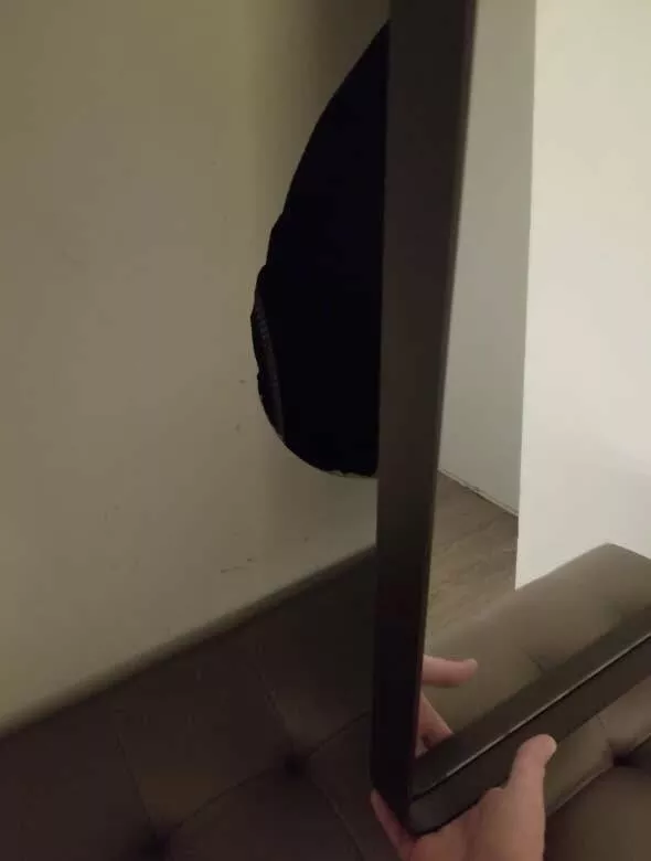Photos effrayantes qui hantent vos reves - #22 Miroir Étrange à l'Hôtel - Un client d'hôtel qui a vu son miroir se secouer inexplicablement, est allé vérifier et a trouvé un grand trou dans le mur avec un espace de rangement derrière.