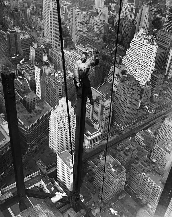Images fascinantes de chantiers historiques - #18 Carl Russell fait signe à ses collègues alors qu'ils travaillent sur la structure au 88e étage du nouvel Empire State Building. On peut apercevoir des voitures miniatures et des piétons ressemblant à des fourmis dans Herald Square, à près d'un quart de mi