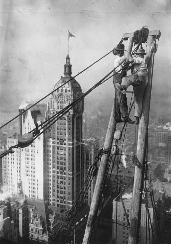 Intriguing images of historical construction projects - #5 Two workers positioned high above lower Manhattan during the skyscraper construction.