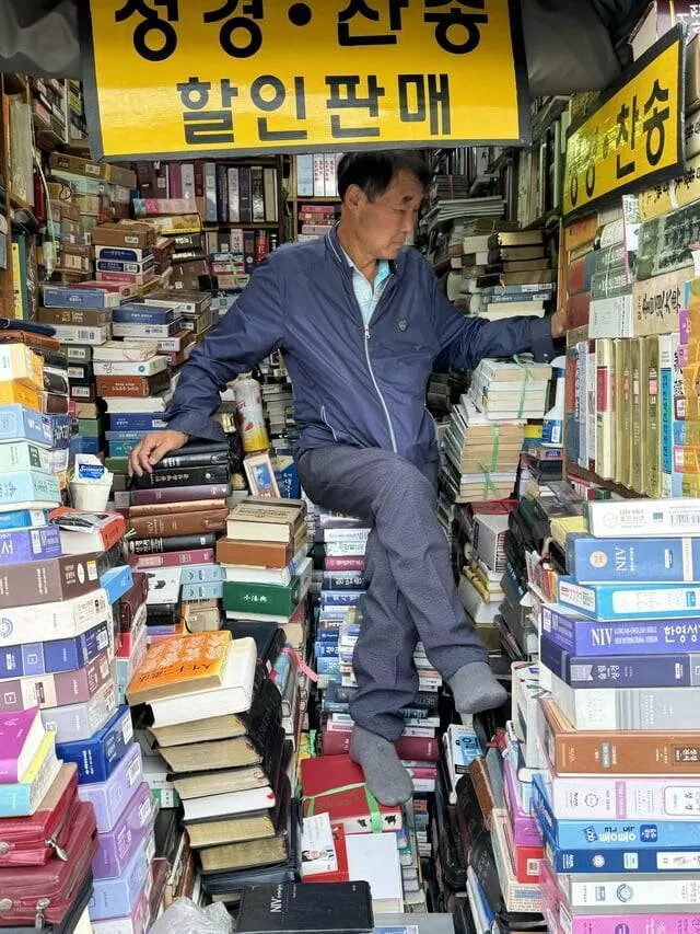 Intriguing photos that will instantly capture your attention - #25 Man Sitting On A Throne Of Books At A Market In Seoul