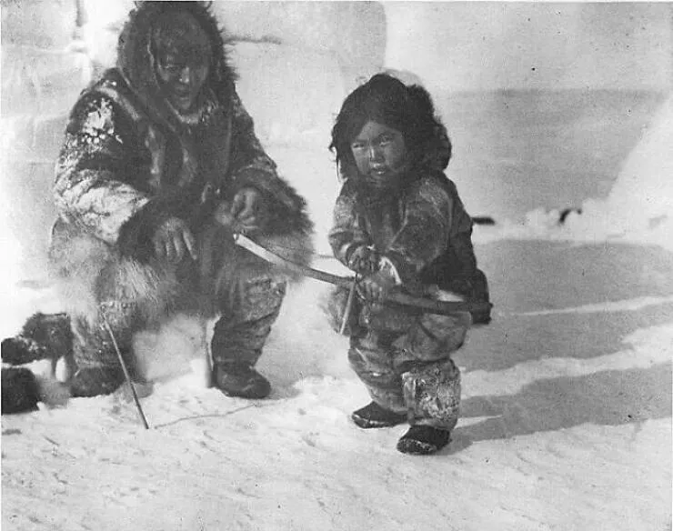Fascinating moments in history captured in photos - #4 Inuk Man Teaches A Young Boy How To Use A Bow And Arrow, Circa 1920