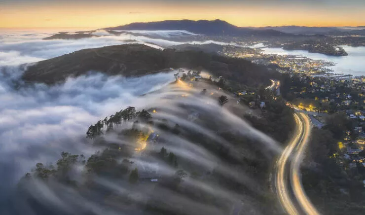 Award winning aerial shots of 2025 - #39 Ray Cao from the USA captures veins of light weaving through foggy rivers