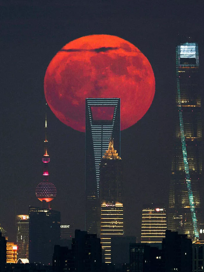 Spectacular space photography that captures distant galaxies - #27 Crimson Eclipse Behind City Towers